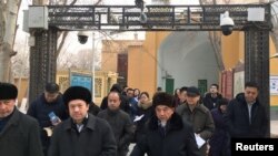 新疆喀什一所清真寺的阿訇2019年1月4日在政府架设的监视器下离开清真寺。