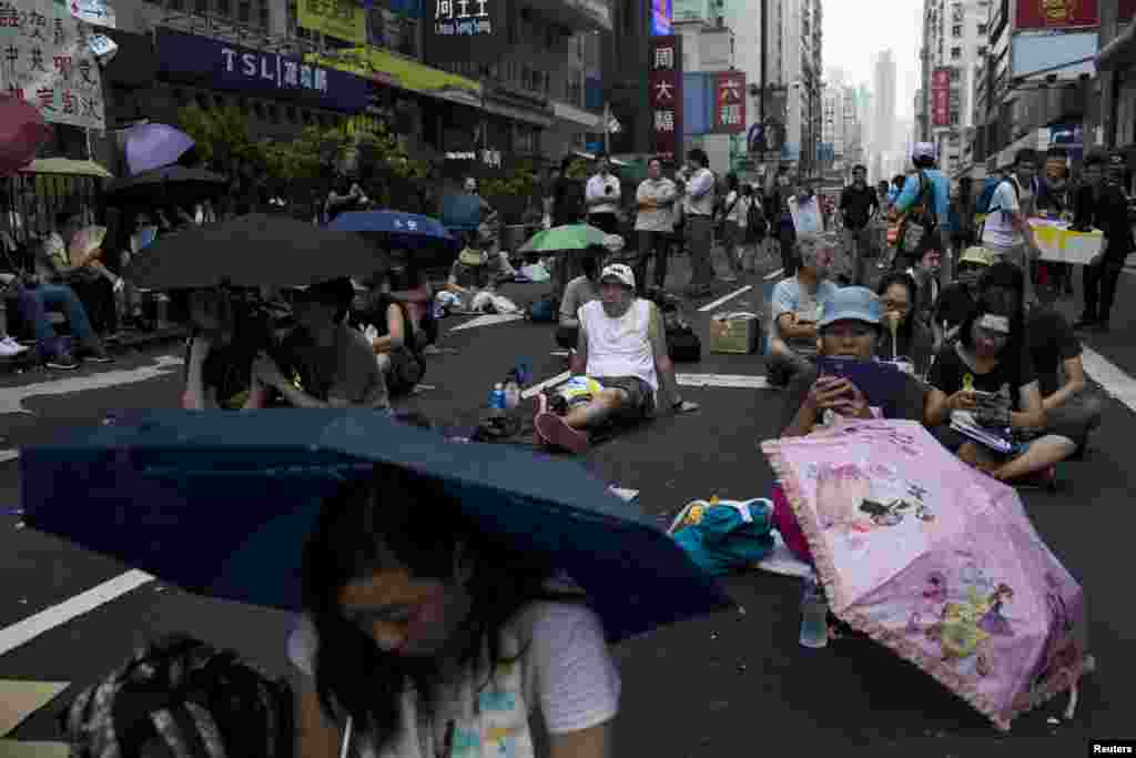 人们在旺角购物区主要街道打伞参加集会