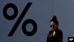一名中国女子2019年4月4日在北京一家商场耳戴苹果无线耳机正在看苹果手机。
