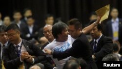 中国全国人大关于李飞在香港介绍北京有关香港政改立场时，梁国雄在现场抗议，被保安人员拖走。（2014年9月1日资料照片）