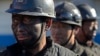 FILE - Miners wait in lines to shower during a break near a coal mine in Heshun county, Shanxi province, Dec. 5, 2014. 
