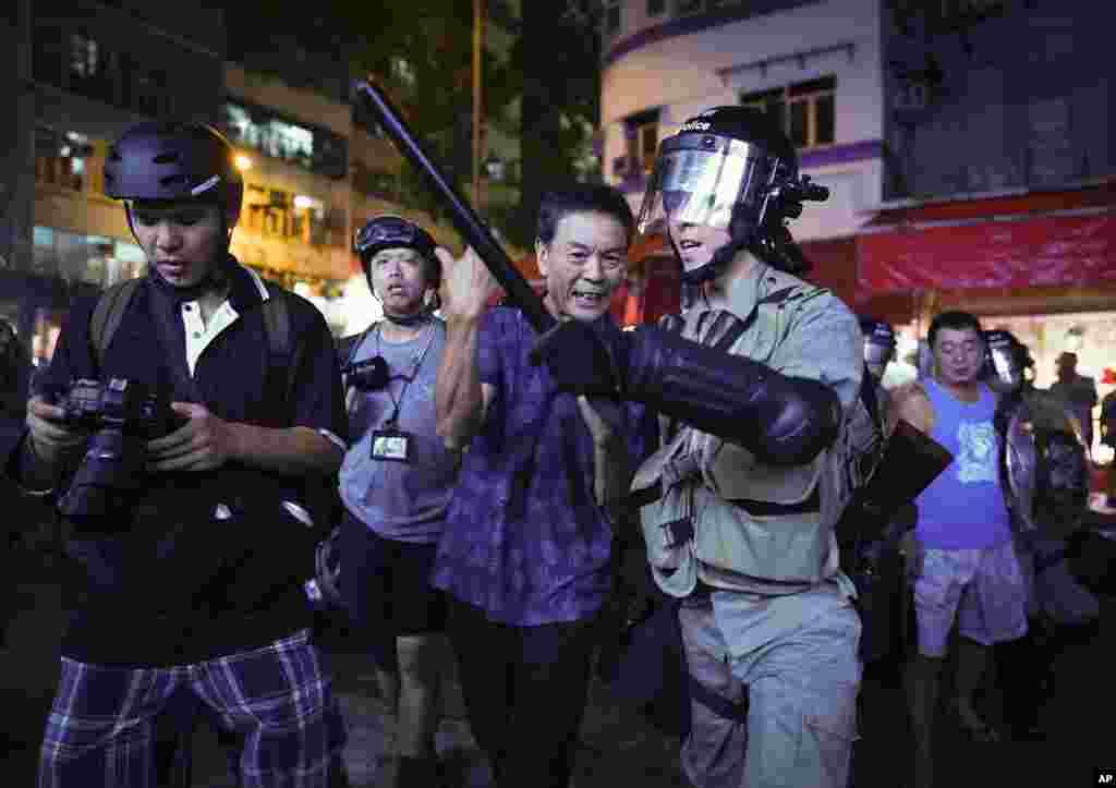一名亲中人士在与一组记者对峙后被香港警方护送走。(2019年9月15日)