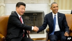美国总统奥巴马（右）在白宫椭圆形办公室接待到访的中国国家主席习近平。（2015年9月25日）