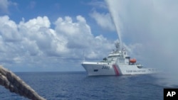 2015年9月23日,中国海岸警卫队成员在南中国海的斯卡伯勒浅滩(Scarborough Shoal)附近与菲律宾渔民对峙。(美联社)