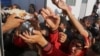 FILE - Displaced Iraqis from the Yazidi community gather for food at the Nowruz camp, in Derike, Syria, Aug. 12, 2014. 