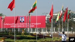图为缅甸一名交警在欢迎习近平的标语牌旁执勤 (1月17日资料画面)