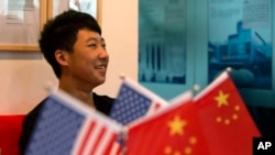 一位16岁的中国学生在北京一家教育机构里的美中两国国旗旁（2014年6月26日）