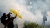 Anti-government demonstrators hold umbrellas against the tear gas during a protest in Hong Kong's tourism district of Tsim Sha Tsui, Oct. 27, 2019.