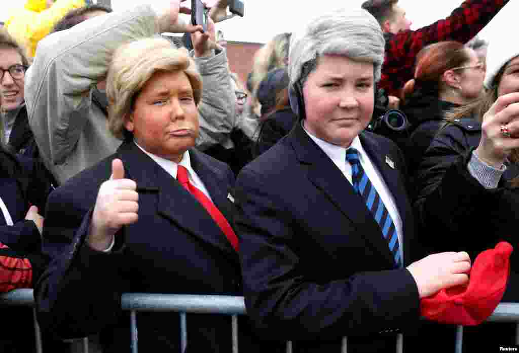Two young men dressed as U.S. President Donald Trump and Vice President Mike Pence welcome Trump as he arrives aboard Air Force One in Salt Lake City, Utah, Dec. 4, 2017.