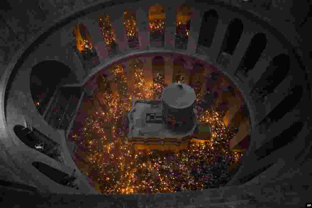 Christian pilgrims light candles during the Holy Fire ceremony at the Church of the Holy Sepulchre, traditionally believed by many Christians to be the site of the crucifixion and burial of Jesus Christ, in Jerusalem's old city, April 7, 2018.