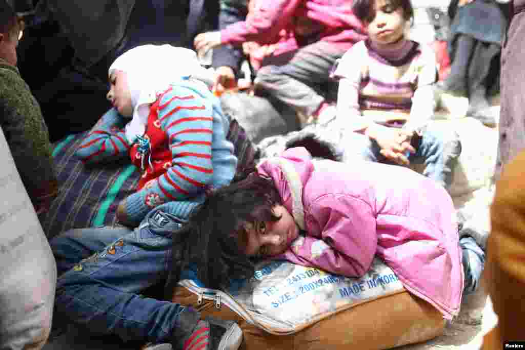 A girl looks at the camera during evacuations from the besieged town of Douma, Eastern Ghouta, in Damascus, Syria.