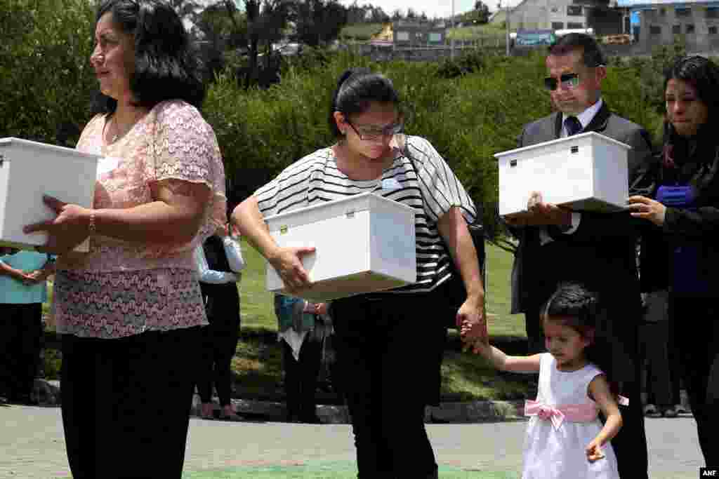 Members of anti-abortion groups and designated adoptive parents hold coffins with the remains of aborted fetuses that had been found at a morgue, during a burial, in Quito, Ecuador, March 13, 2018.