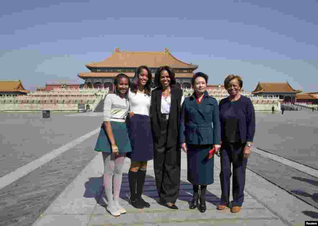 美国第一夫人米歇尔.奥巴马、她的女儿玛丽雅和萨莎,以及她的母亲罗宾逊女士3月21日在参观北京的故宫时与中国国家主席习近平的夫人彭丽媛合影。