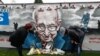 People view a mural of late record-breaking centenarian Captain Tom Moore, who died on Tuesday, in Two Gates, Tamworth, Britain, Feb. 3, 2021.