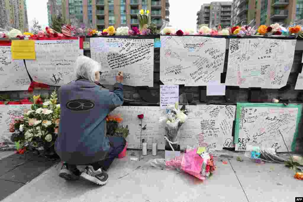 Jack Young leaves a notes at a makeshift memorial for victims in the van attack in Toronto, Ontario. A van driver who ran over 10 people when he plowed onto a busy Toronto sidewalk was charged with murder, as Canadian Prime Minister Justin Trudeau urged a rattled nation not to live in fear after the "senseless attack."