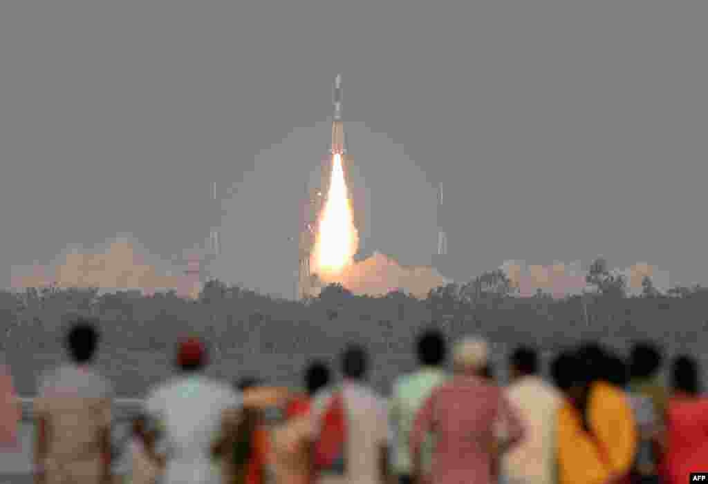 Indian onlookers watch as the Indian Space Research Organisation's (ISRO) GSAT-6A communications satellite launches on the Geosynchronous Satellite Launch Vehicle (GSLV-F08) from Sriharikota in the southern state of Andhra Pradesh.