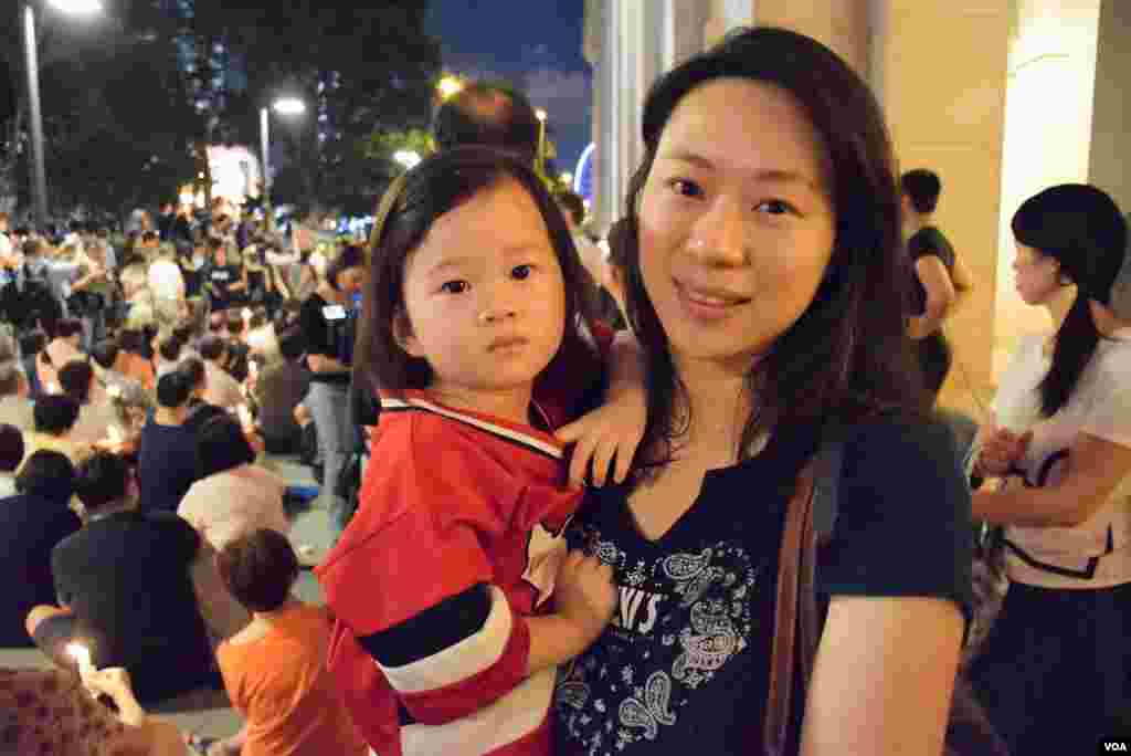 一位姓陈的香港市民带着她两岁的女儿参加香港市民支援爱国民主运动联合会(简称支联会)6月29日晚上在香港中环终审法院外举行烛光集会,要求北京无条件释放刘晓波 。(美国之音汤惠芸拍摄)