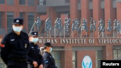 在世卫组织新冠病毒源头调查组视察武汉的中国科学院病毒研究所期间，中国保安人员在研究所外站岗。 （路透社 2021年2月3日）