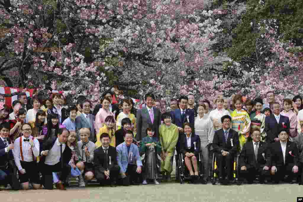 东京新宿御苑,日本首相安倍晋三举办的观赏樱花派对上,安倍戴着粉红色领带,与日本艺术家、演艺人员、运动员和其他客人合影。(2017年4月15日)