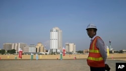 资料图：一名中国建筑工人站在一带一路工程项目斯里兰卡科伦坡港口城工地上。(2018年1月2日)