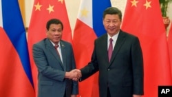 中国国家主席习近平在北京人大会堂与参加一带一路峰会的菲律宾总统杜特尔特握手。（2017年5月15日）
