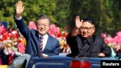 韩国总统文在寅和朝鲜领导人金正恩2018年9月18日在平壤乘车向朝鲜民众挥手致意。