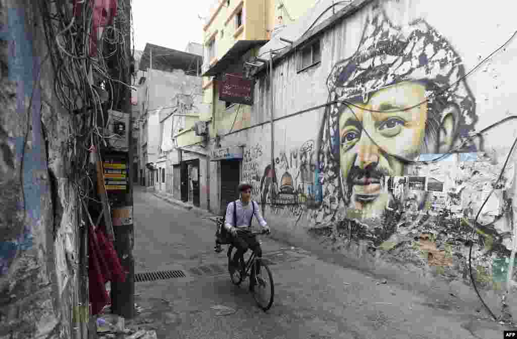 Mohammed, a Lebanese roaming barber, better known as &quot;Abo Tawila&quot;, rides his bicycle in a street on the outskirts of the Palestinian refugee camp Burj al-Barajneh, south of the capital Beirut, Lebanon.