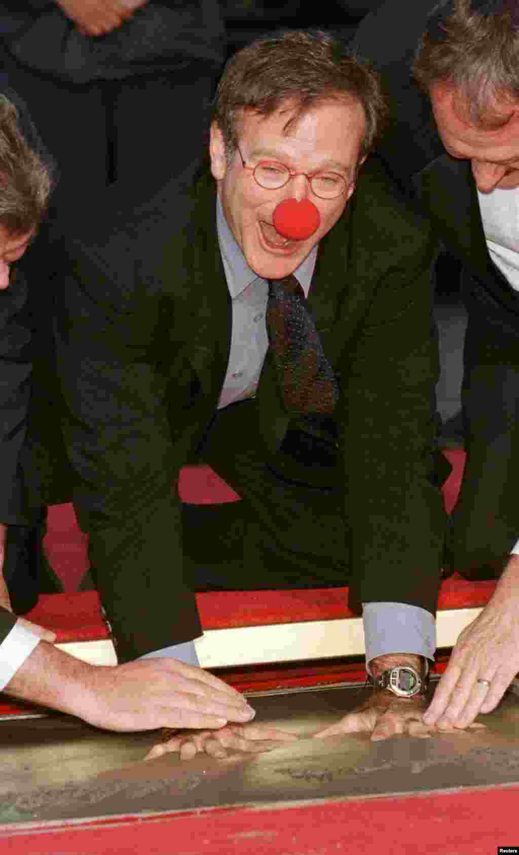 Robin Williams đùa giỡn trong lúc in dấu tay lên xi măng trong buổi lễ vinh danh ông tại nhà hát Mann's Chinese Theater ở Hollywood, ngày 22/12/1998.