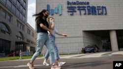 两名女子从位于北京的TikTok母公司字节跳动的总部旁走过。（2020年8月7日）