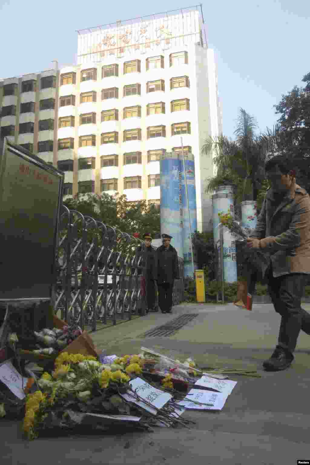 2013年1月7日,一个人在南方周末总部前面安放一束菊花