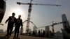Workers walk out from a construction site at the Central Business District of Beijing, China, Jan. 20, 2015.