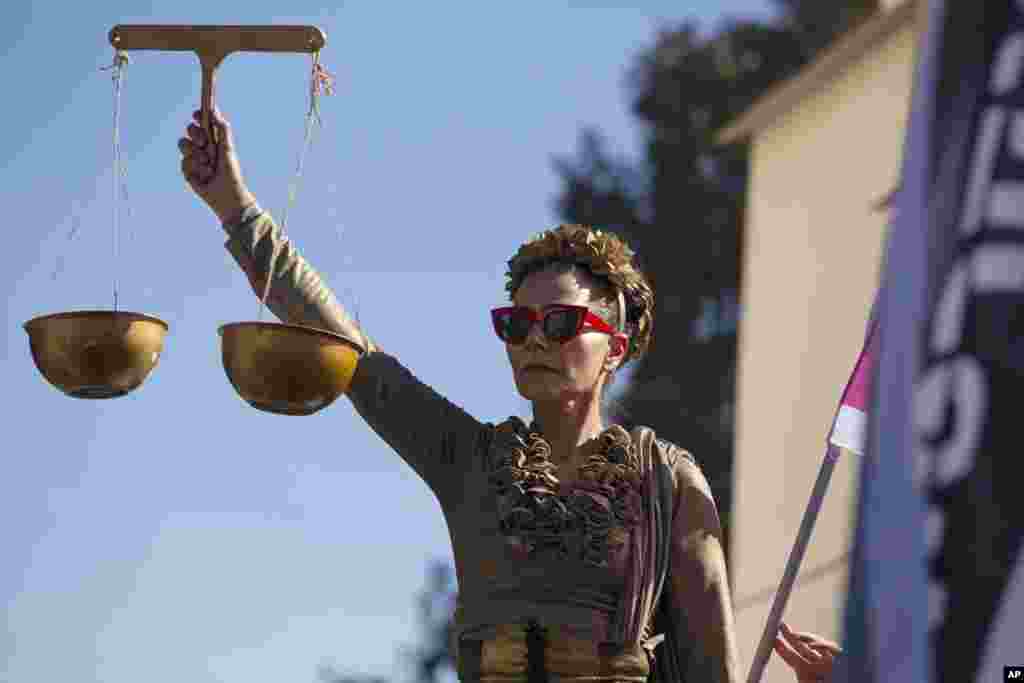 A protester holds the scales of justice outside the District Court during a hearing in Israeli Prime Minister Benjamin Netanyahu's corruption trial, in Jerusalem.
