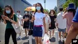 北京，人们戴着口罩穿过一个十字路口（2020年6月5日）。