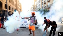 黎巴嫩反政府抗议者用网球拍击回防爆警察发射的一枚催泪弹。(2020年8月10日)