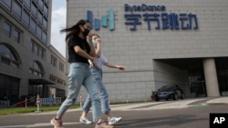2020年8月7日戴着口罩的行人走过TikTok北京总部大楼