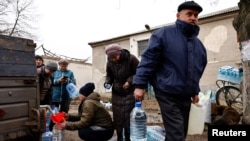 Мешканці містечка Часів Яр, що поблизу Бахмута, наповнюють пляшки свіжою питною водою, яку привезли в район лінії фронту після ураження критичної цивільної інфраструктури під час нападу Росії на Україну. Архівне фото 16 березня 2023 року. REUTERS/Віолета Сантос Моура/Фото з файлу