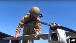 На цьому відеокадрі з відео пресслужби Міноборони Росії 8 серпня 2022 року, видно, як російський військовослужбовець готує до запуску розвідувальний безпілотник "Орлан-10". (Фото пресслужби Міноборони РФ через AP)