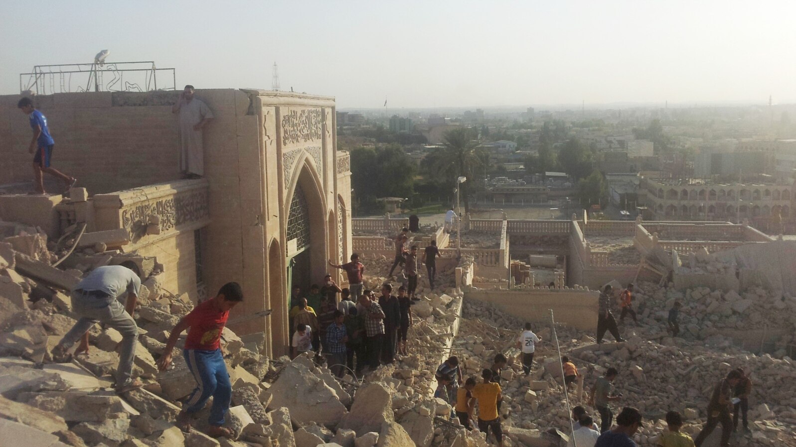 FILE - In this July 24, 2014 file photo, people walk on the rubble of the destroyed Mosque of The Prophet Younis, or Jonah, in Mosul, 225 miles (360 kilometers) northwest of Baghdad, Iraq. 