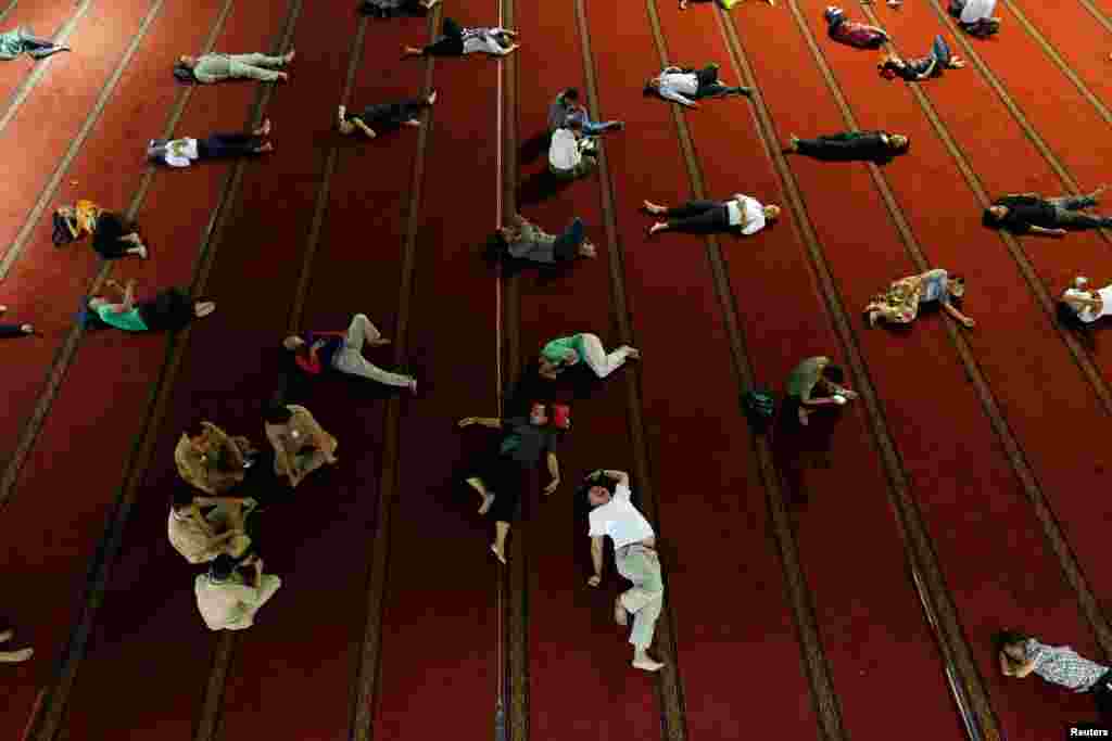 People sleep as they wait for iftar during the holy month of Ramadan at Istiqlal mosque in Jakarta, Indonesia.