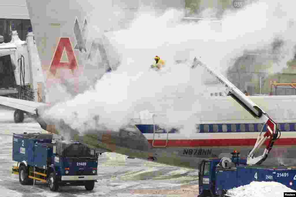Phi hành đoàn của hãng hàng không American Airlines làm tan băng cho một chiếc máy bay tại Boston, ngày 2/1/2014.