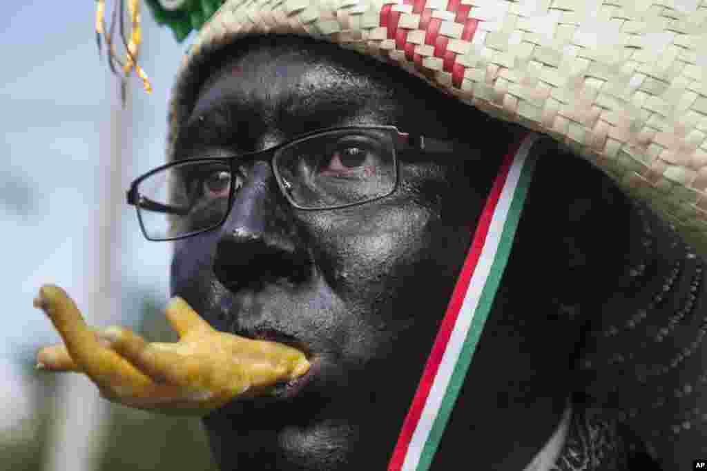 A man dressed as a revolutionary Zacapoaztla indigenous soldier eating a chicken leg marches during a re-enactment of The Battle of Puebla between the Zacapoaztlas and French army as part of the Cinco de Mayo celebrations in Mexico City, May 5, 2018.