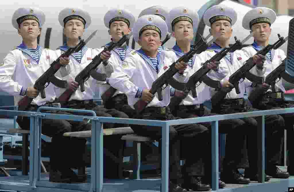 平壤金日成广场4月15日的阅兵式上展示的一枚潜射弹道导弹前面，坐着海军军人