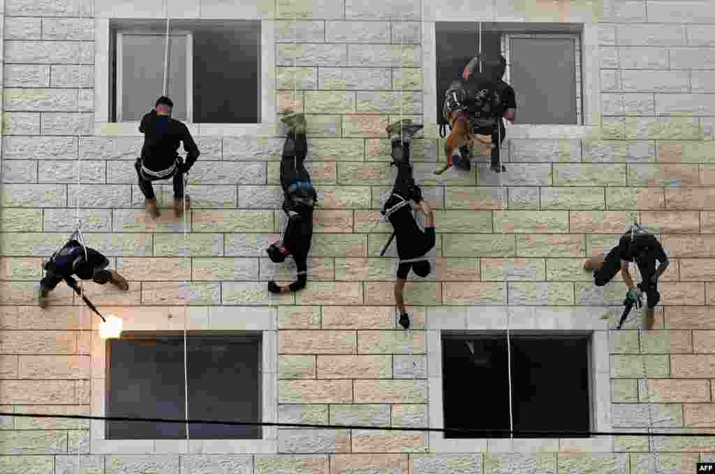 Palestinian members of Hamas' security forces rappel along the wall of a building as they show off their skills during a police graduation ceremony in Gaza City.