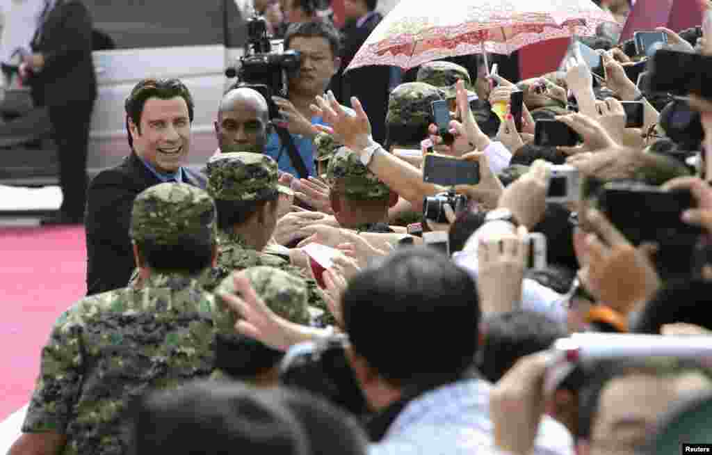 美国影星約翰・特拉沃塔 (John Travolta)参加万达集团在青岛投资建设的,全球投资规模最大的影视产业基地――青岛东方影都的推广活动,和影迷握手(2013年9月22日)。