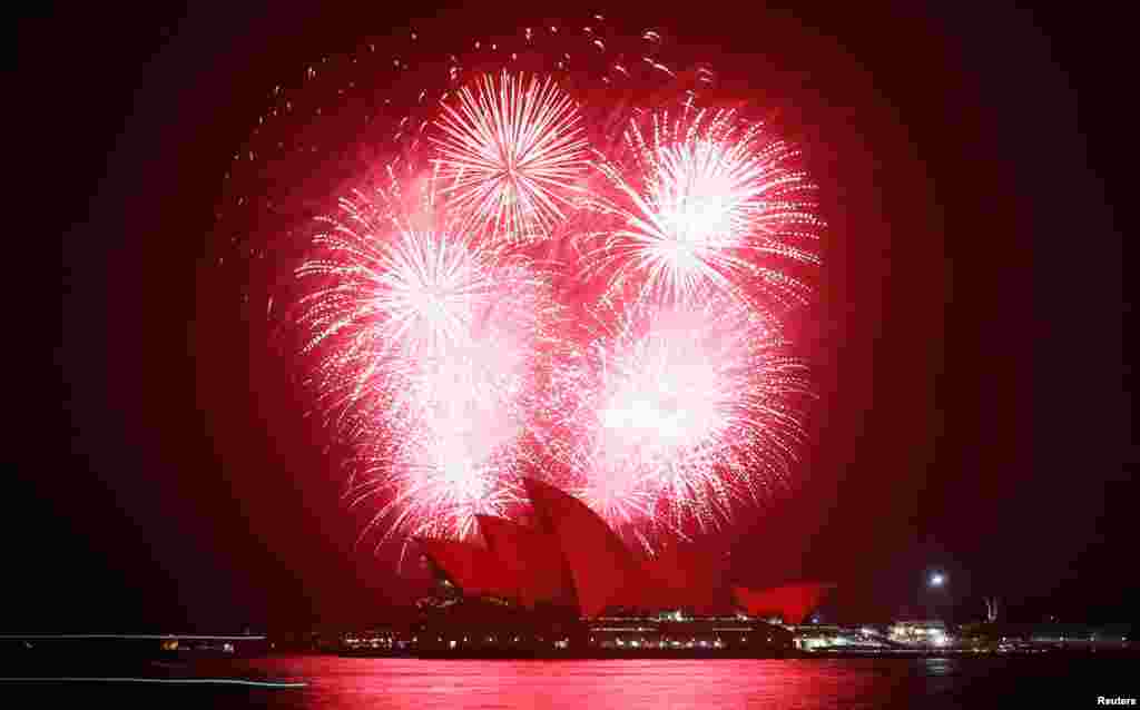 2012年11月30日,为纪念世界艾滋病日,悉尼歌剧院上空烟火齐放,剧院沐浴在红光之下。