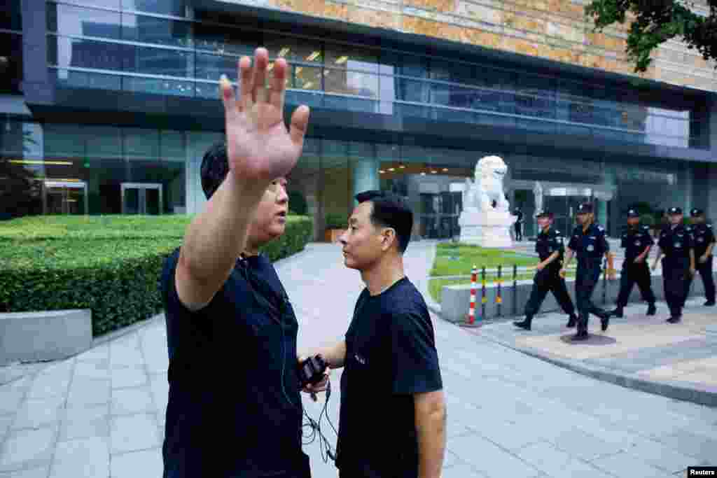 在北京的中国银监会入口处,保安人员巡逻,一位警察对摄影者摆出姿势,似乎示意不让拍照。中国网贷平台集资受害者准备到这里请愿。当局严阵以待(2018年8月6日)。