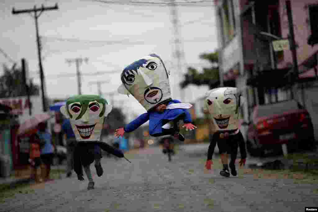Member of the "Group Boi Faceiro" wear masks known as "Cabecudos" and take part in carnival festivities in Sao Caetano de Odivelas, Brazil, Feb. 13, 2018.