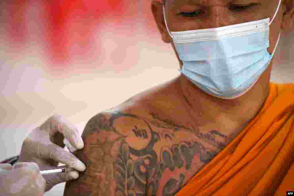 A Buddhist monk receives a dose of China's Sinovac coronavirus disease (COVID-19) vaccine at a temple in Bangkok, Thailand.