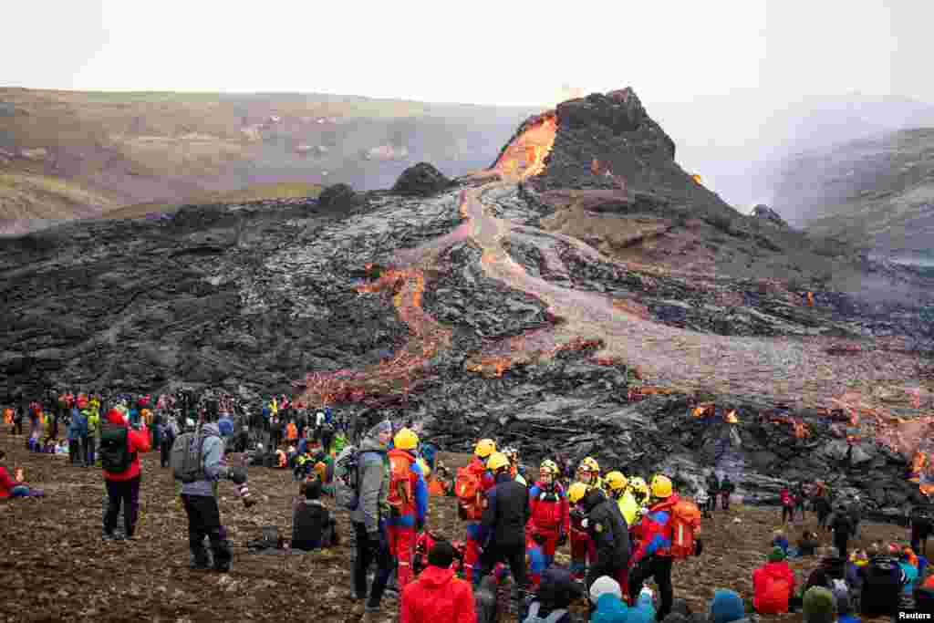 People gather at the volcanic site on the Reykjanes Peninsula following Friday's eruption in Iceland, March 21, 2021.