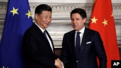 2019年3月23日，中国国家主席习近平(左)与意大利前总理孔特在签署“一带一路”倡议的备忘录后握手。